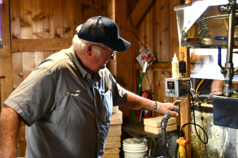 Fred Hervey closely monitors the temperature of the evaporator during the production of maple syrup.