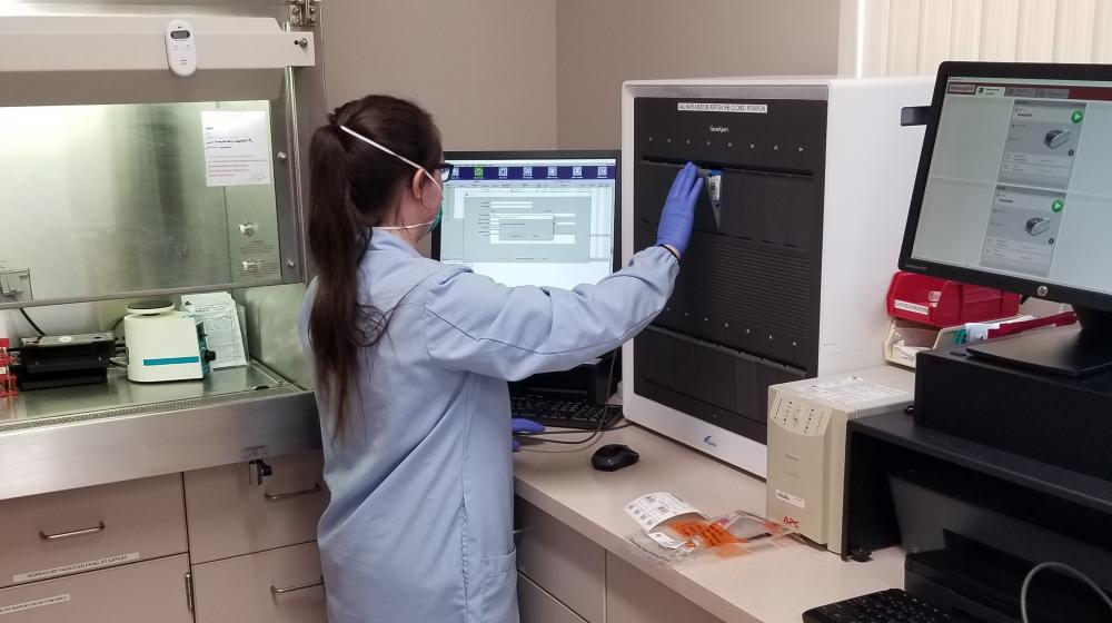 Lab technician using new COVID-19 testing machine 