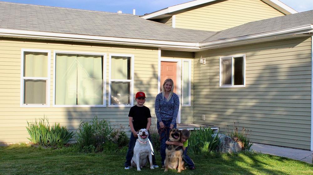 Amanda and her family in front of their new home 