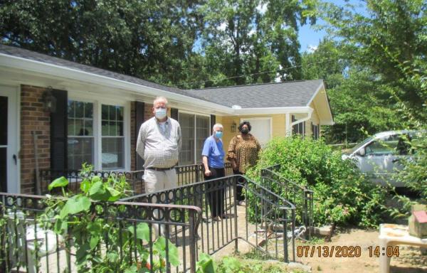 Ms. Dearing on her porch (center) social distance visiting from USDA housing program team members Wes and Qula.