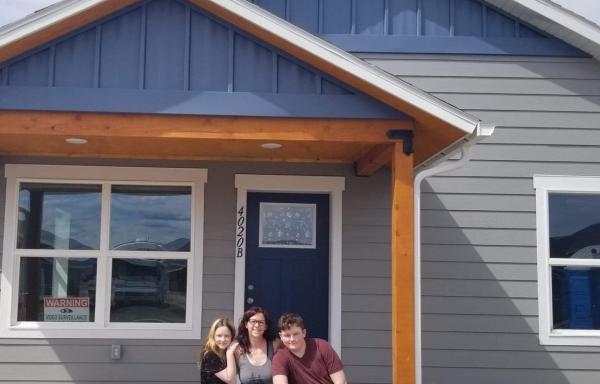 A picture of Amber and her family in front of the house they built