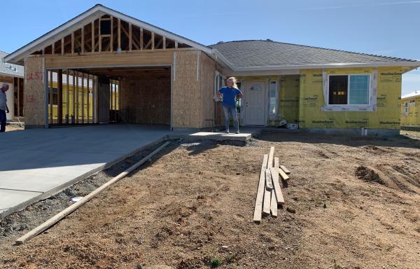 Sherry Parker poses for a photo by the construction of her new home  in Northern Calirfornia. Parker lost her home during the devastation of the Camp Fire in 2018. (USDA Courtesy Photo)