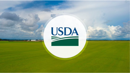 USDA logo in front of arial view of plush green farmland with trees and a farm out in the distance. It is daytime and the clouds are big and various colors of blue and white.