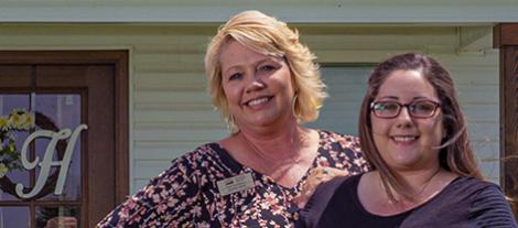 two women in front of home