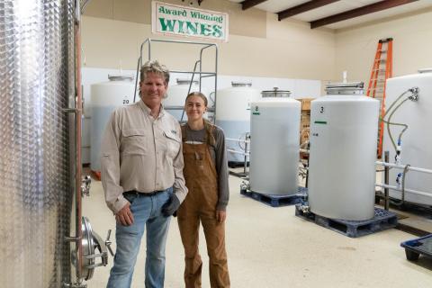 Man and woman standing in wine fermentation room