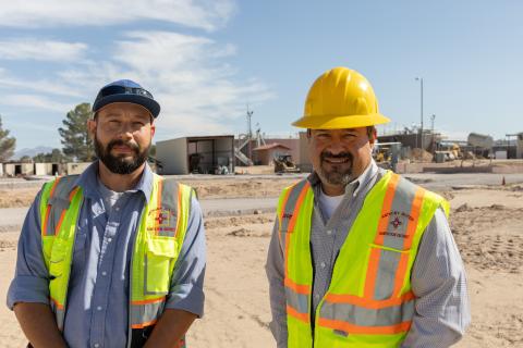 Two men standing next to each other in reflective vests