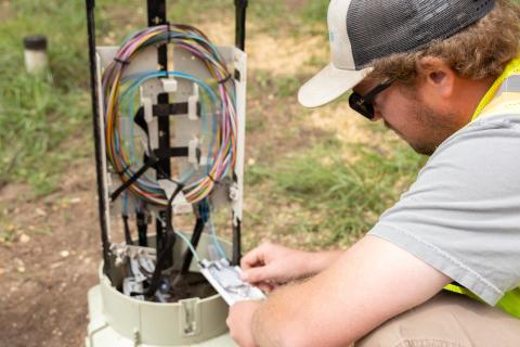 man looking in fiber cable box