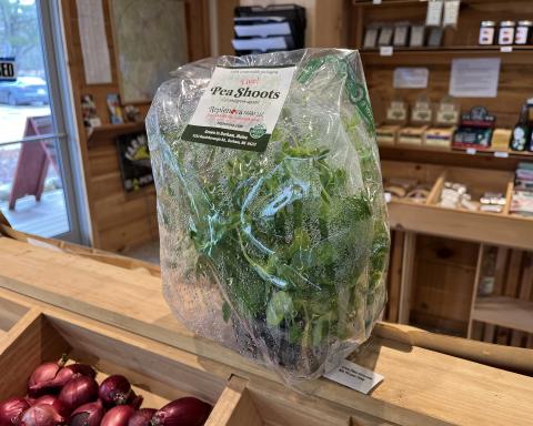 Replenova Farm pea shoots are pictured in a compostable bag on a shelf in the shop.