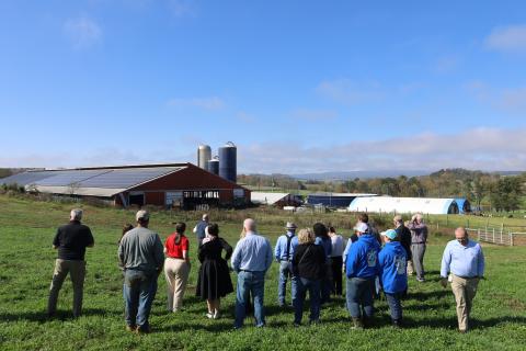 A small crowd gathers on the pasture at Main Street Milk Farm in Somerset, Pa., on Nov. 3, 2024, to see the farm’s roof mounted solar project.