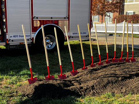Shovels lined up near fire truck.