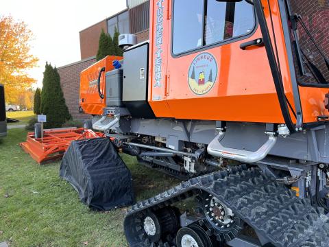 The club's dragger is shown attached to a new snow grooming machine at a snowmobile show in Augusta, Maine in October 2024.