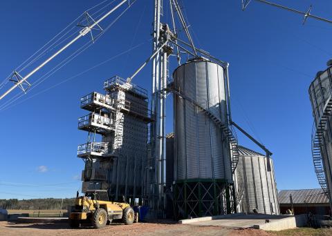 The farm's new grain dryer is located in the midst of a wide expanse of fields.