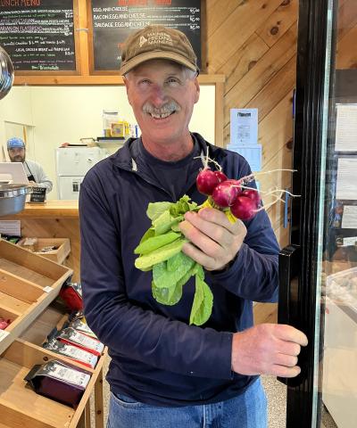 Gary Goodrich is shown holding fresh produce in his farm market.