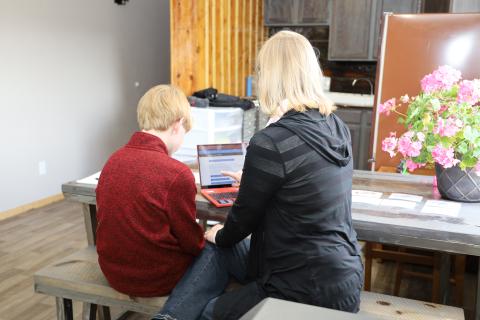 Two people sitting in front of a computer