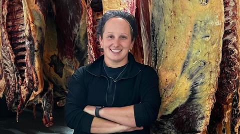 Katie Adkins stands with cuts of meat