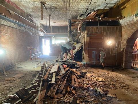 The interior of the Bighorn Bottle Shop and Wine Bar during renovation - a wall is torn down and debris is scattered on the floor.
