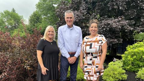 USDA RD Chief Operating Officer Roger Glendenning stands with Head of School Heather King (in black) and Prinicipal Rachel Merrill on the school grounds.