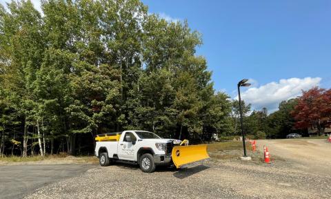 Truck with front plow by parking lot
