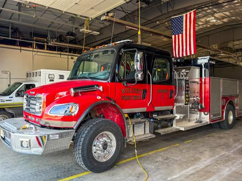 fire truck inside building with American flag hanging from ceiling
