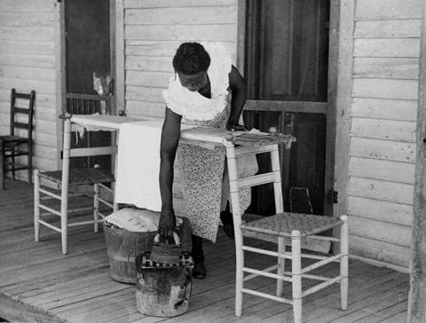 photo of black woman ironing clothes