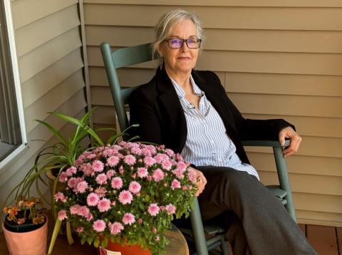 Lisa Gallant, homeowner, sits in a rocking chair on her front porch.