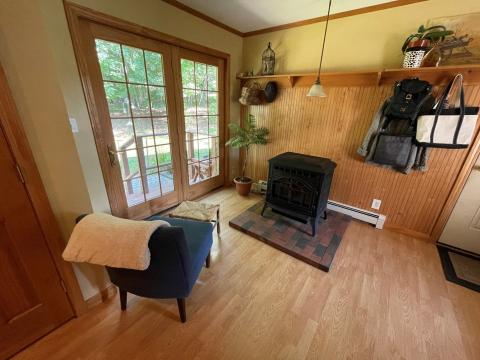 A cozy seating area off the kitchen in Lisa Gallant’s South Paris home is complemented by a pellet stove and a paint shade called “Blonde.”