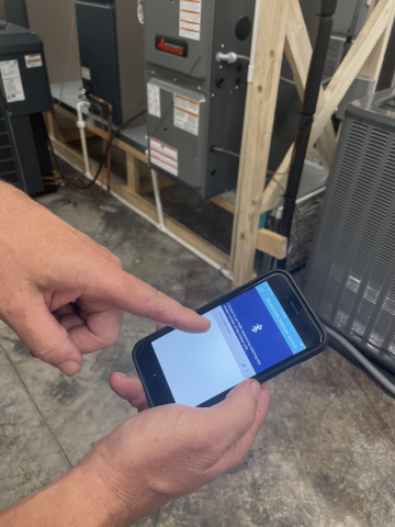 Brian Watson using the phone apps to connect to the HVAC system