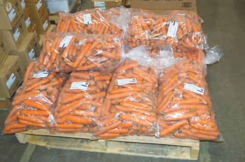 Carrots ready for transport, stored in plastic bags on a pallet