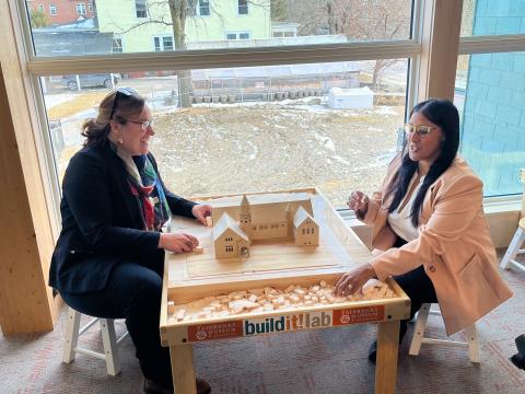USDA RD State Director Sarah Waring and RD Deputy Under Secretary Farah Ahmad play with wooden blocks
