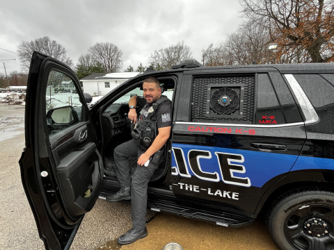 Police officer sitting in police vehicle.