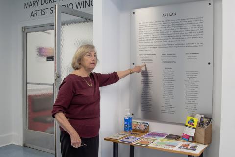 Betsy White points to an inscription on a plaque outside of the Art Lab.
