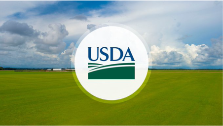USDA logo in front of arial view of plush green farmland with trees and a farm out in the distance.  It is daytime and the clouds are big and various colors of blue and white.