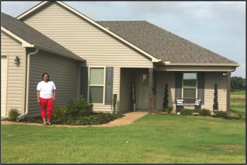 Ms. Veronica Williamson, standing in front of her newly constructed home.