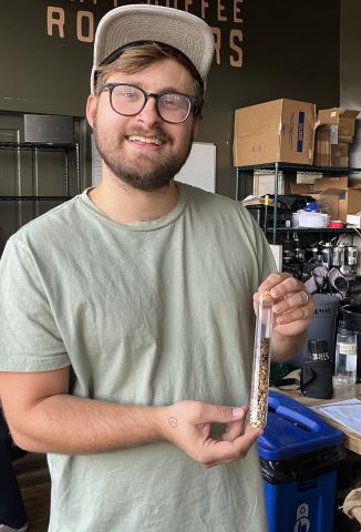 Aaron Mallory holds up a sample of his coffee beans