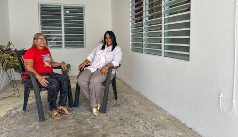 Carmen and her daughter Carmen sit outside of the renovated house