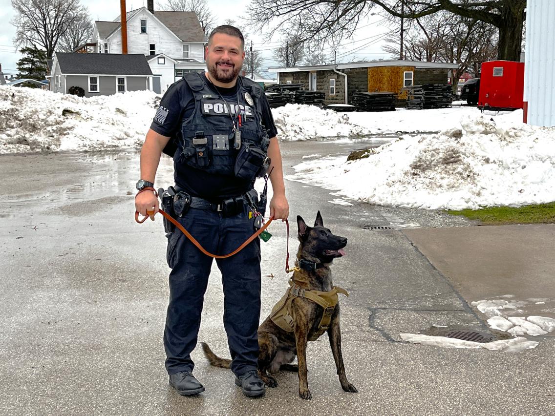 Police officer standing with dog.