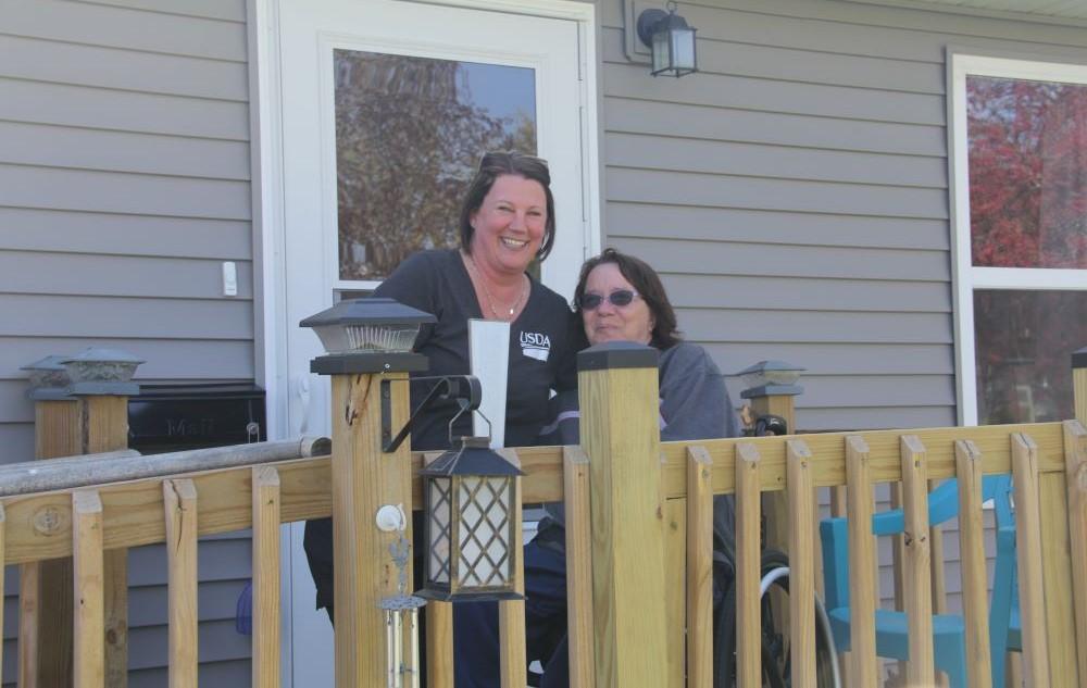 Two people on the deck of a house