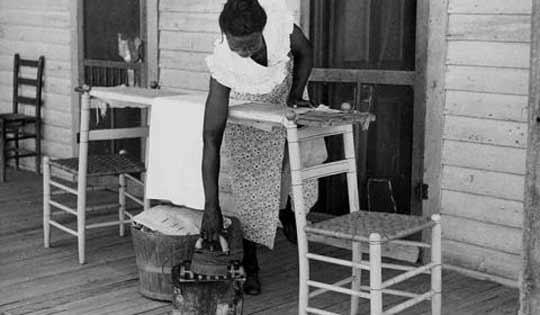 Black and white image of a lady ironing in the 1940s