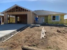 Sherry Parker poses for a photo by the construction of her new home in Northern Calirfornia. Parker lost her home during the devastation of the Camp Fire in 2018. (USDA Courtesy Photo)