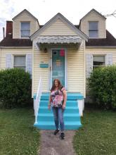 June Walker stands in front of her home.