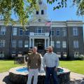 State Director Jim Carmack and Crook County Commissioner Seth Crawford stand outside the county courthouse, which was built in 1909.
