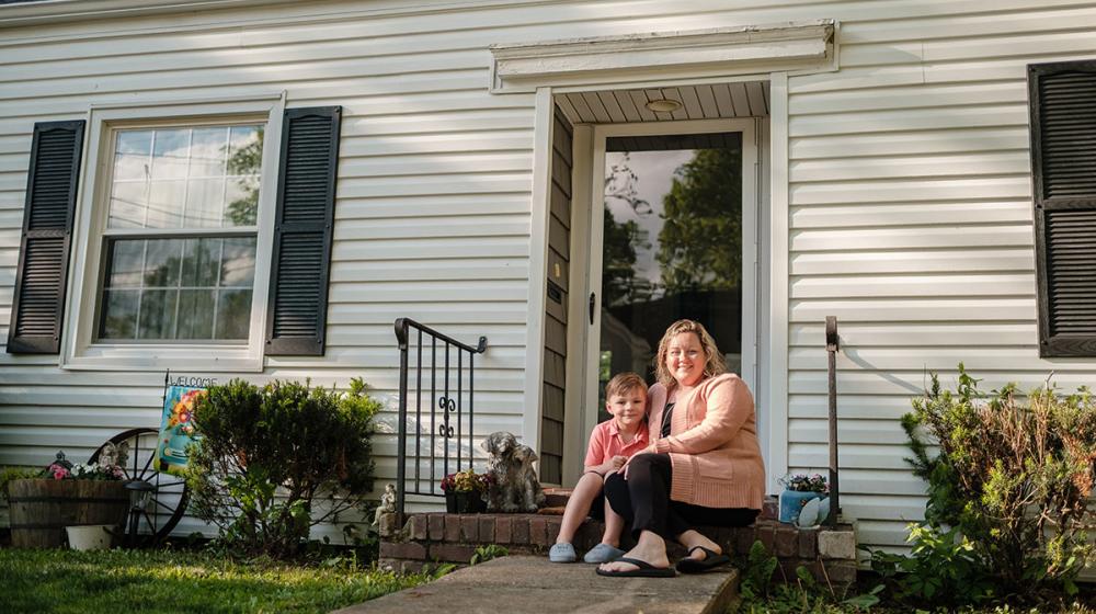 Alicia and her son, Sy, outside their new home