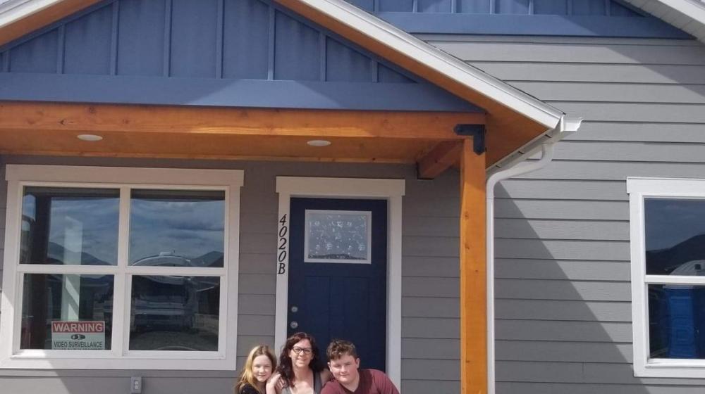 A picture of Amber and her family in front of the house they built