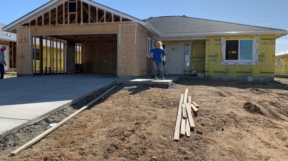 Sherry Parker poses for a photo by the construction of her new home in Northern Calirfornia. Parker lost her home during the devastation of the Camp Fire in 2018. (USDA Courtesy Photo)