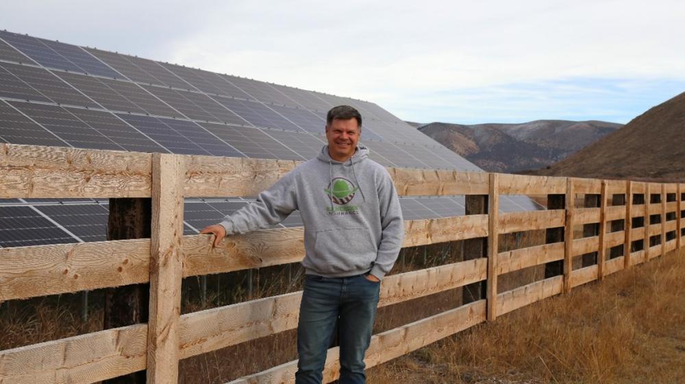 Brandon Willis, Rancher's Insurance owner standing in front of ground mounted solar panels in Laketown, Utah.