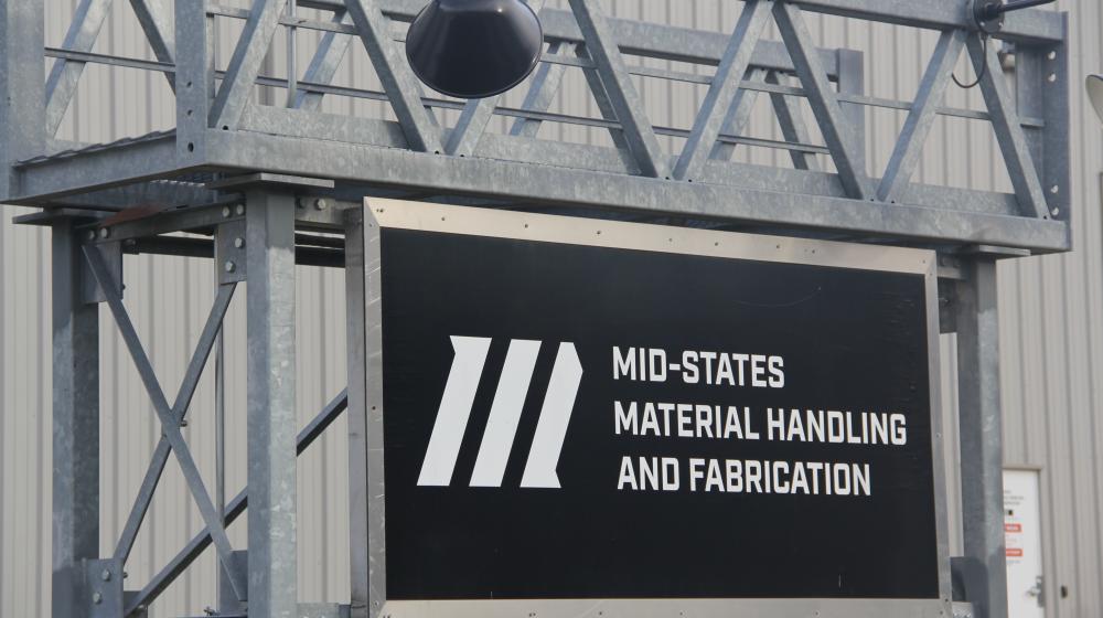 A sign in front of an industrial building states Mid-States Material Handling and Fabrication
