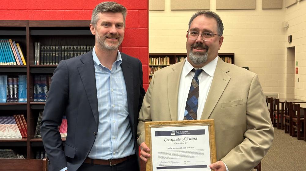 Ohio state director presents certificate to Jefferson Local School District Superintendent.