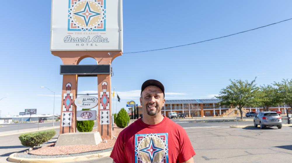 Man standing in front of Desert Aire Hotel sign