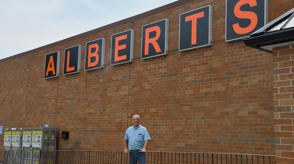 Man standing in front of grocery store. 