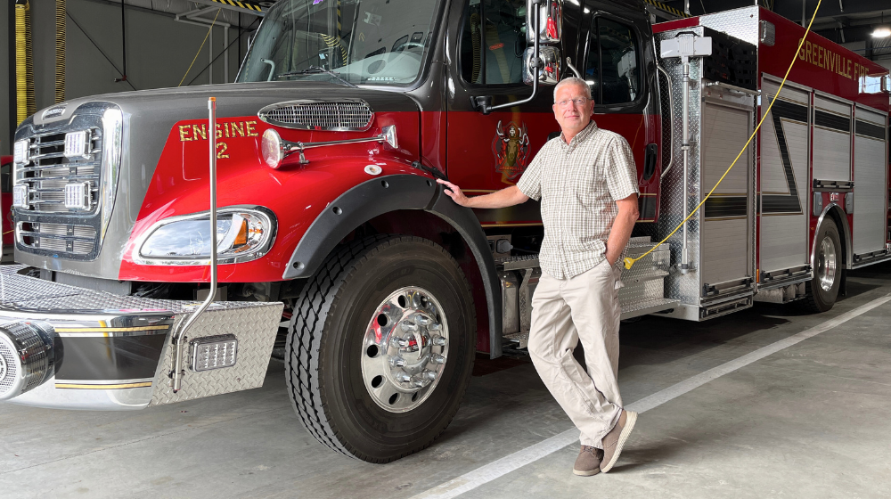 Greenville Town Manager Mike Roy stands in front of one of the town's fire trucks in the new public safety building.